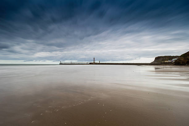 istock Whitby Harbour and lighthouse from the beach 613310472
