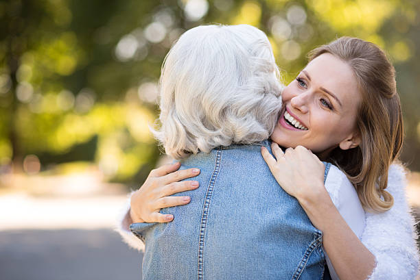 istock Two amused women embracing in the park. 613310746