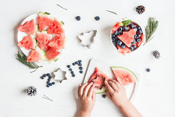 istock Children's hands cooking christmas fruit salad. Top view, flat lay 613313144