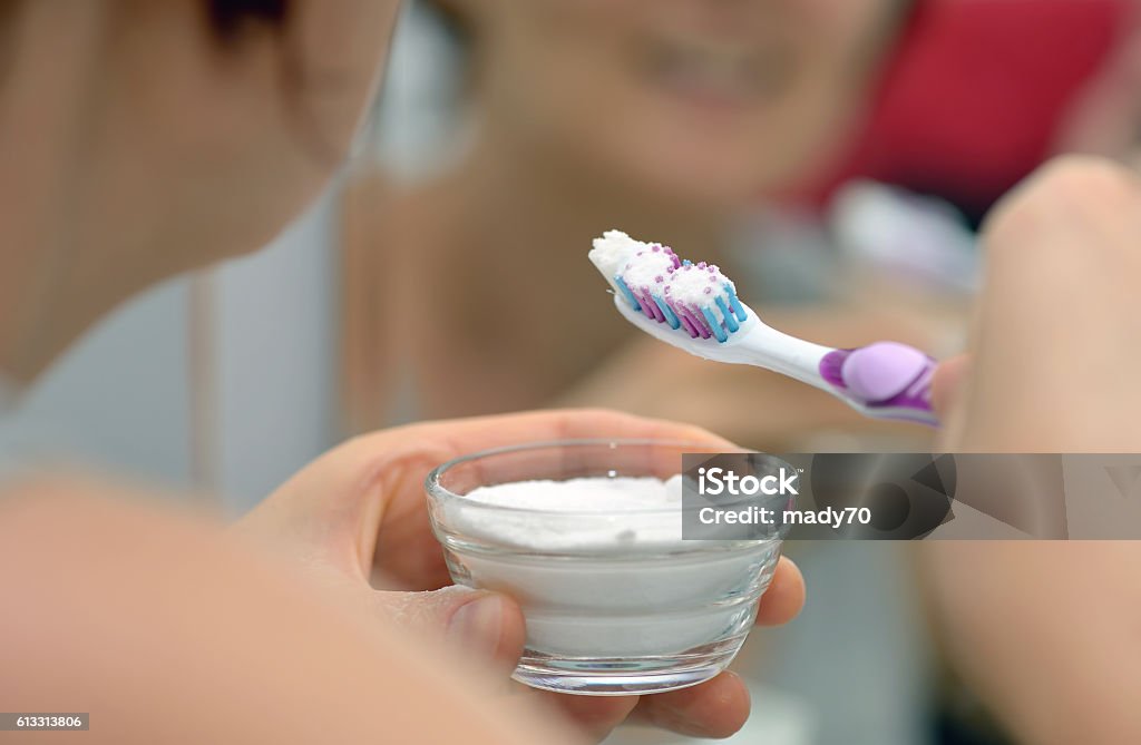 brightening teeth with sodium bicarbonate Woman brightening teeth with sodium bicarbonate Acid Stock Photo