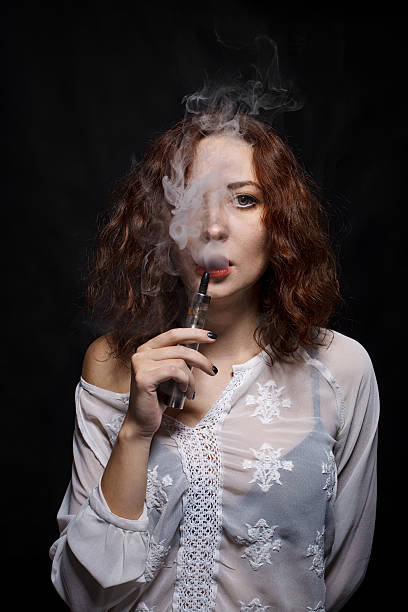 istock Woman smoking  electronic cigarette 613314222