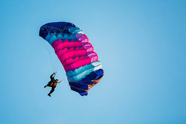 istock Skydiver On Colorful Parachute In Blue Clear Sky 613316256