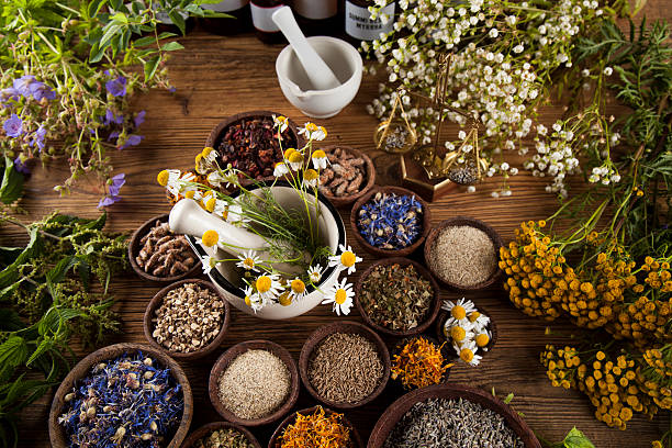 istock Natural medicine, herbs, mortar on wooden table background 613317022