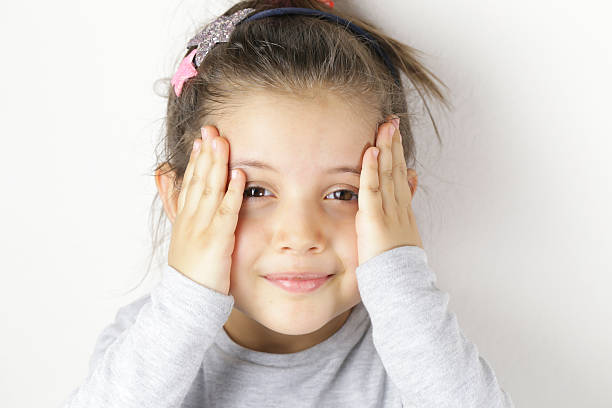 istock little girl propped his head on his hands 613317586