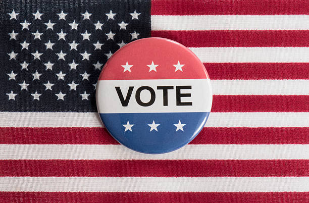 istock Vote button sitting on the American flag 613319142