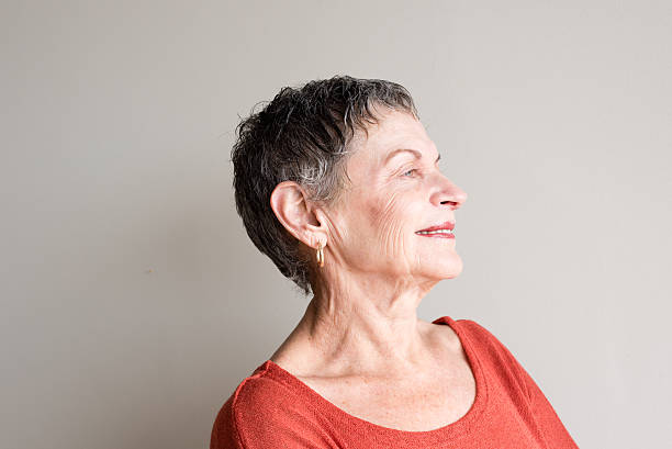 istock Older woman smiling with head back 613319636