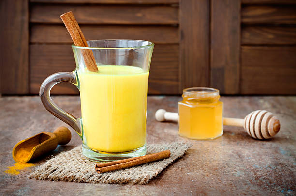 Turmeric golden milk latte with cinnamon sticks and honey