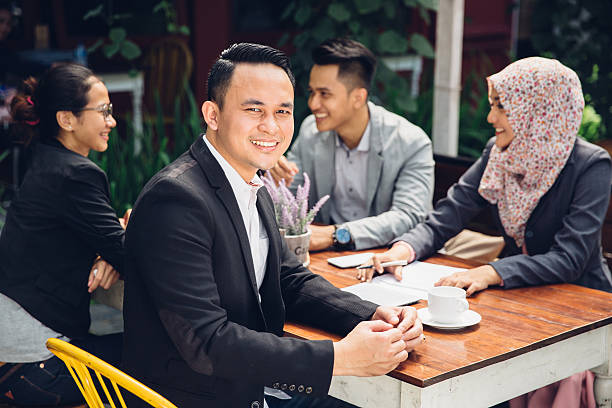 istock handsome businessman smiling at the camera 613326256