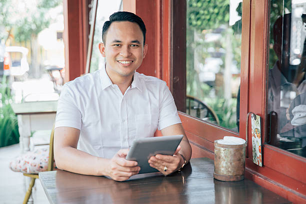 istock Young successful businessman with tablet in cafe 613327508