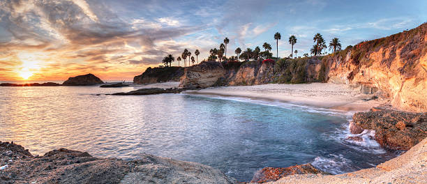 blick auf den strand von treasure island bei sonnenuntergang - orange county california beach stock-fotos und bilder