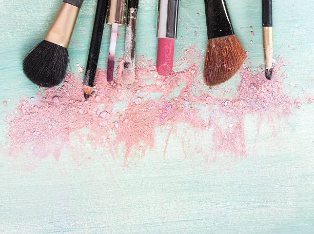 istock Makeup brushes and lipstick on teal blue background 613331766