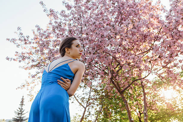 istock Beautiful young woman standing near the apple tree. 613331996