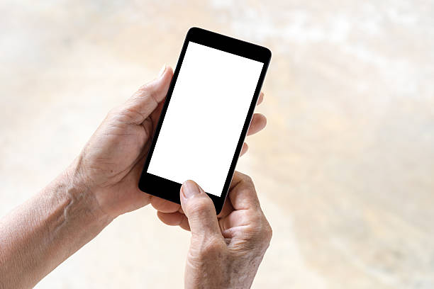 persona mayor, mano usando la pantalla blanca del teléfono - one old woman only fotografías e imágenes de stock