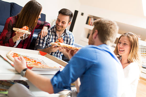 istock Friends eating pizza 613333120