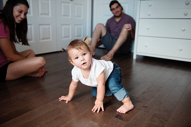 baby-mädchen geht mit hilfe der hände - child human foot barefoot jeans stock-fotos und bilder