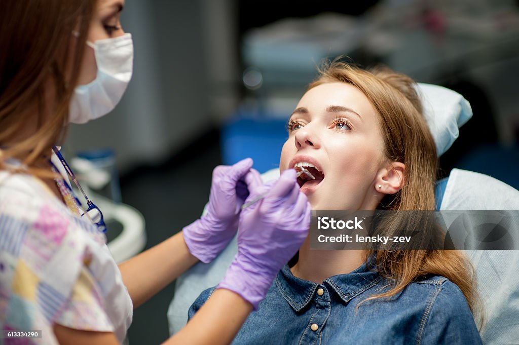 Dentist curing a child patient in the dental office Dentist curing a child patient in the dental office in a pleasant environment. There are specialized equipment to treat all types of dental diseases in the office. Cleaning Stock Photo