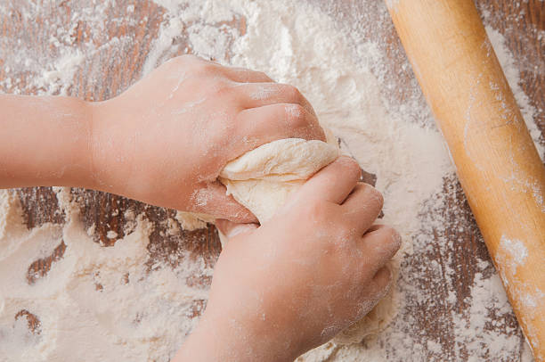 istock kid's hands kneading the dough 613338444