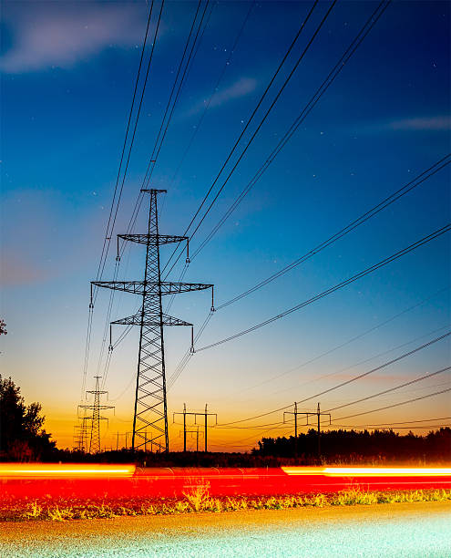 istock high voltage post. High-voltage tower sky background, besides the highway 613338592