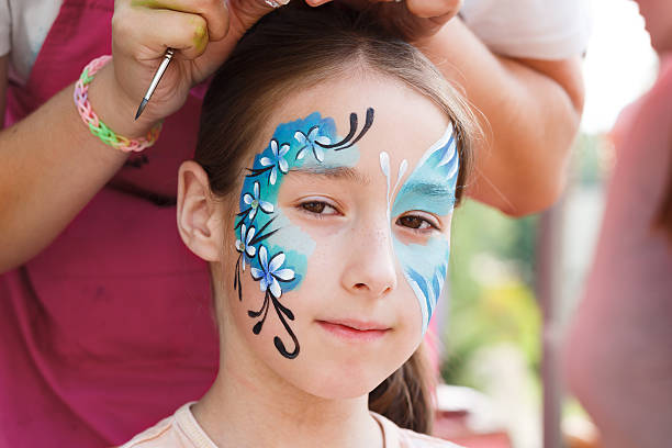 istock Female child face painting, making butterfly process 613341200