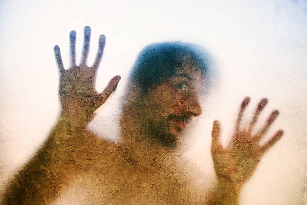 istock Trapped man, back lit silhouette of hands behind matte glass 613342614