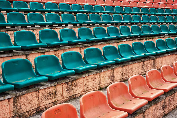 istock Empty old plastic seats at stadium, open door sports arena. 613345526