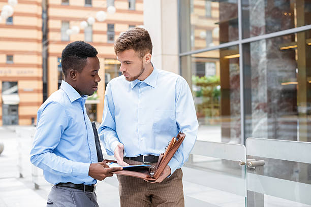 two businessmen talking and looking at documents - suit male beauty men businessman imagens e fotografias de stock