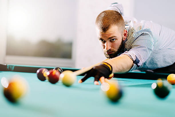 istock Handsome young man plying billiard 613347950
