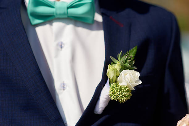 istock white wedding boutonniere on Groom's jacket 613348196