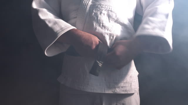 Judokas Fighter tying black belt