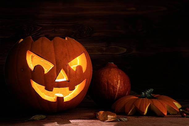 istock Carved halloween pumpkin on dark rustic wood 613518864