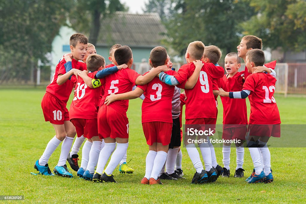 kids soccer team in huddle kids soccer team in group huddle Child Stock Photo