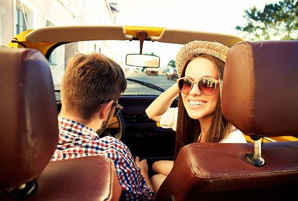 istock handsome couple looking at camera sitting in car 613520890