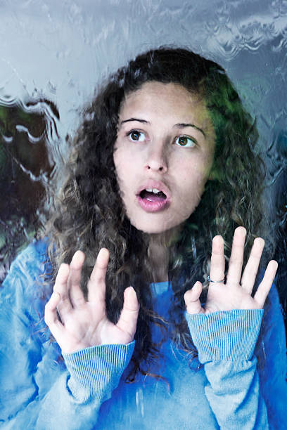 istock Sad young beauty touching window looks out at rain 613520906