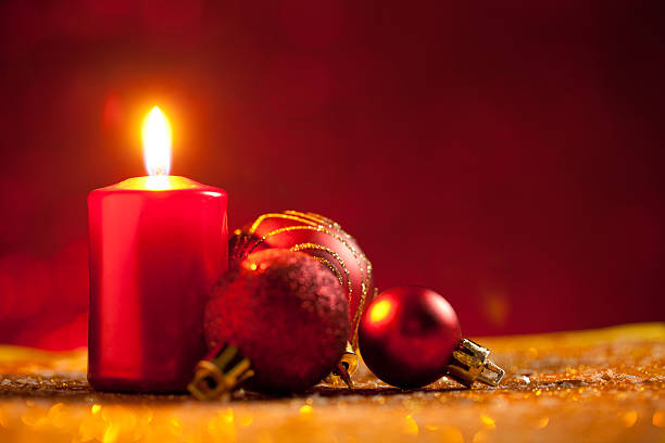 istock Candle and baubles on glitter with red background 613521226