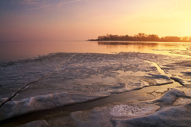 istock Winter landscape with frozen river and sunset sky. 613522800