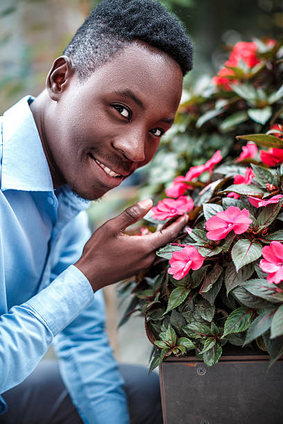 istock man  sniffing the flowers 613525868