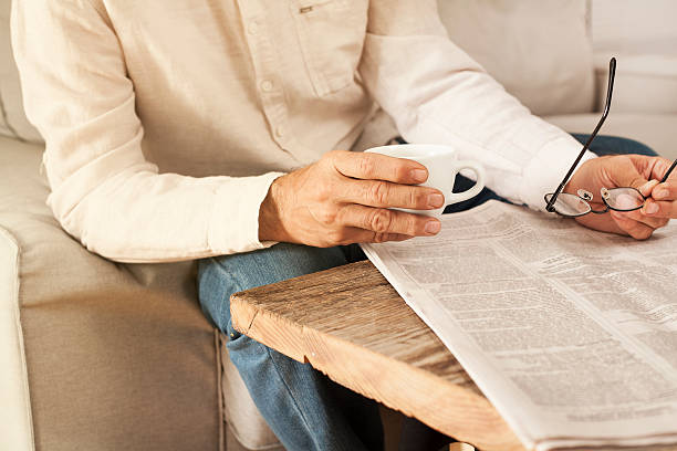 istock Man reading newspaper in home 613526234