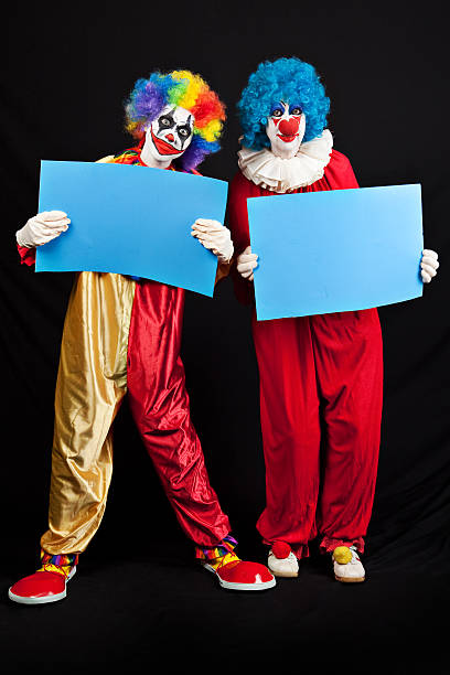 istock Creepy Clowns Holding Blank Signs 613527450