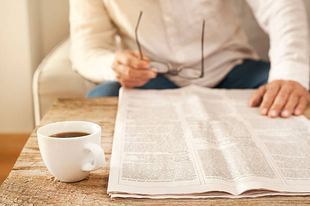 hombre leyendo periódico en casa - reading newspaper break tea fotografías e imágenes de stock