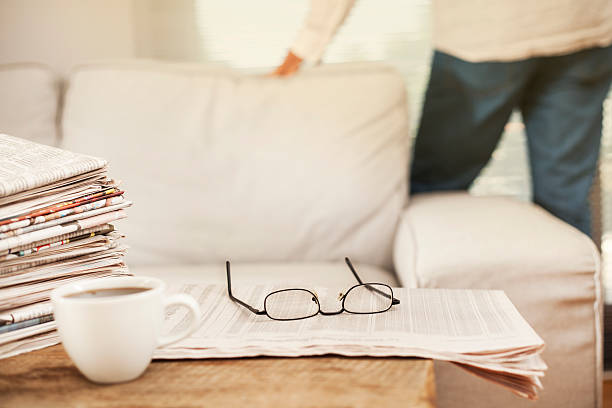 istock Man reading newspaper in home 613528388