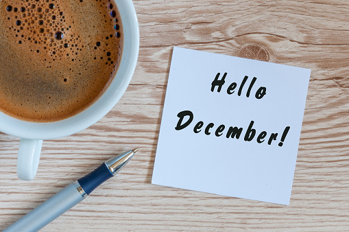 Hola diciembre escrito en papel cerca de la taza de café de la mañana en photo