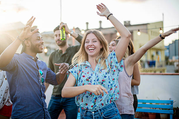 istock Friends dancing and laughing on a rooftop party 613529636