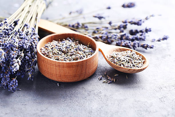 istock Lavender flowers in bowl and spoon on grey table 613531028
