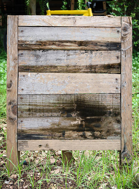 istock Old wooden board on grass in garden. 613531192