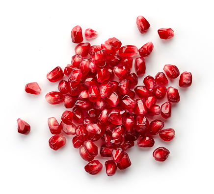 Heap of fresh pomegranate seeds isolated on white background, top view
