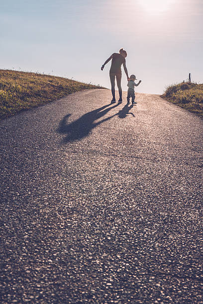 istock Baby walking with help of its parents - first steps 613532470