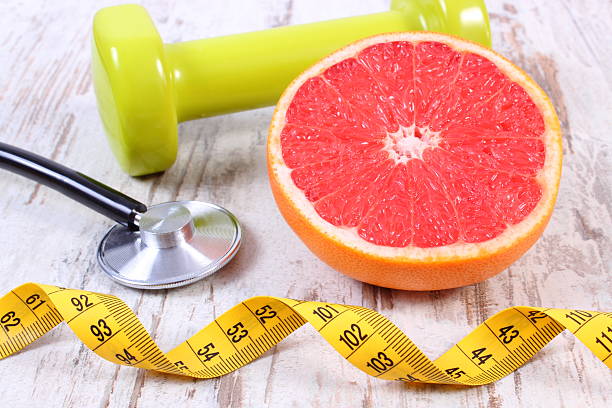 istock Fresh grapefruit, centimeter, stethoscope and dumbbells, healthy lifestyles 613532884