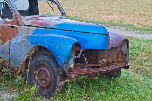 Abandoned and forgotten -  disused car is on a dirt road