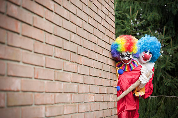 istock Creepy Clowns Peeking Around A Brick Wall 613533952