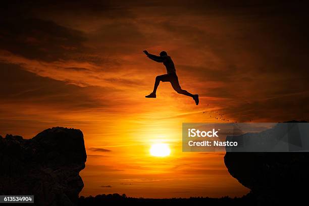 Jumping Over Abyss Stock Photo - Download Image Now - Jumping, Motivation, Courage